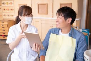 歯医者さんでスタッフに褒められている患者様の写真