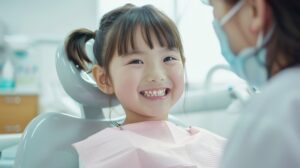 笑顔で歯医者の診察を受ける女の子の写真