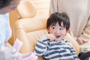 子どもが安心した様子で歯科健診を受けている写真