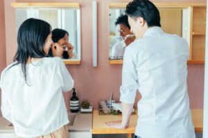 洗面所で就寝前の歯磨きをしている男女の写真